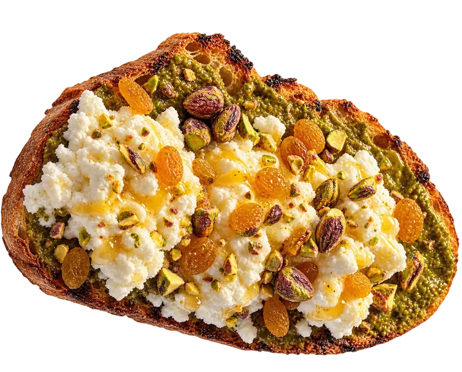 Toast spread with pistachio butter, topped with cottage cheese, golden raisins, pistachios and honey